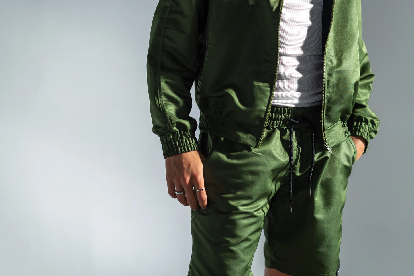STMNT Wear green athletic shorts and jacket detail showing elastic waist and drawstring closure