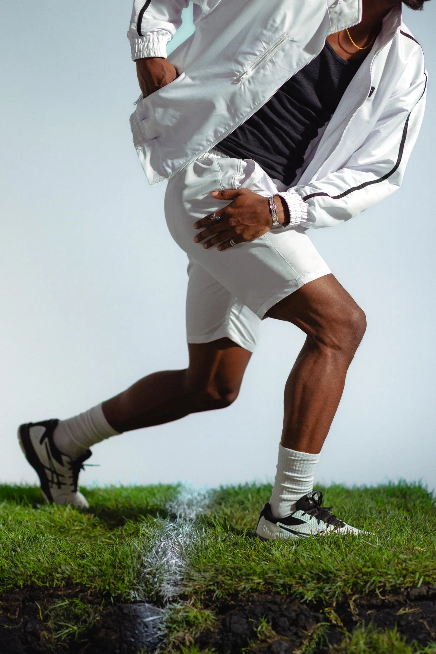 STMNT Wear white athletic shorts in running stride showing movement and fit on soccer pitch turf cut-out in a studio