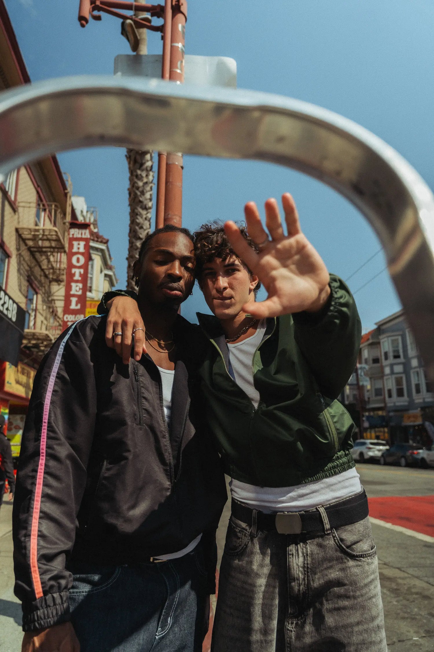 Two models in STMNT Wear jackets posing on a San Francisco street - urban soccer streetwear campaign